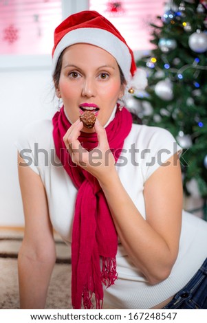 Woman eats chocolate and dreaming of Christmas gifts