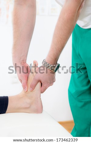 Chiropractor massage foot with both hands female patient