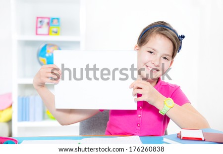 Smiling little girl holding an empty white card for you sample text
