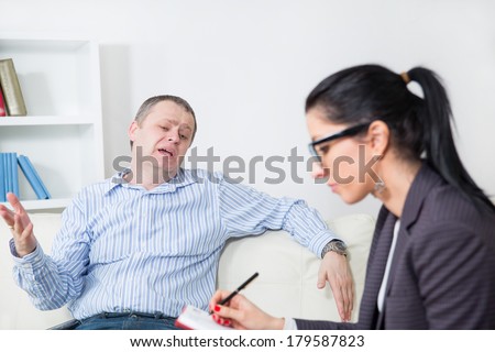 Business man reclining comfortably on a couch talking to his psychiatrist