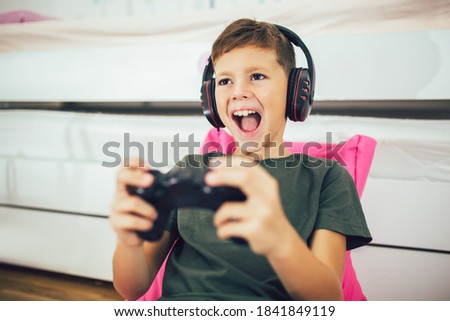 Little boy with gamepad playing video game at home ストックフォト © 