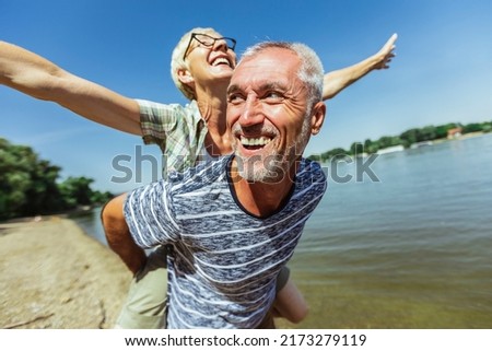 Portrait of happy mature man being embraced by his wife at the beach.  Photo stock © 