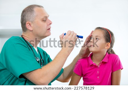 Eye doctor examining young girl patient - Ophthalmology