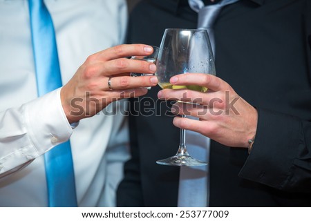 Elegant men in a business suit, holding glass of wine,