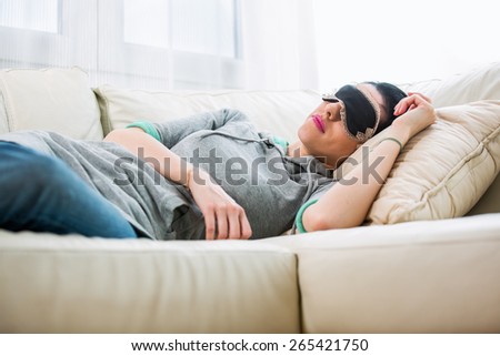 Young woman lies with sleeping mask.Afternoon rest in the living room
