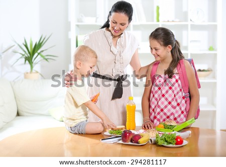 Mother making breakfast for her children in the morning and a snack for school