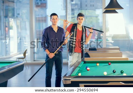 Two guys in pool billiard club playing pool billiard