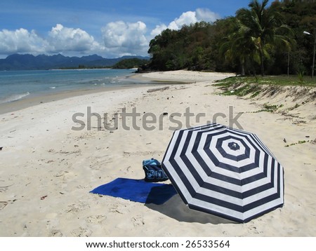 Striped umbrella on a desert beach of Langkawi island, Malaysia
