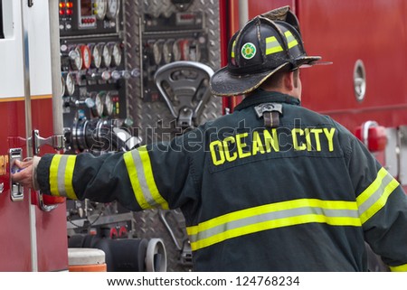 OCEAN CITY - SEPTEMBER 26: Unidentified firefighter standing by the fire truck at the fire scene in Ocean City Maryland on September 26 2012 Ocean City Volunteer Fire Company was established in 1905