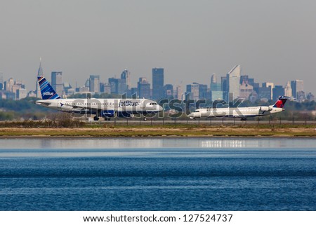 NEW YORK - DECEMBER 8: Airbus A320 JetBlue and Bombardier  jet airliner Delta on JFK in New York USA on December 8, 2012 JFK airport is New York\'s main international airport opened in 1948