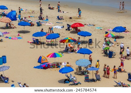 OCEAN CITY - JUNE 14: Tourists on the beach in Ocean City, MD on June 14, 2014. Ocean City, MD is a popular beach resort on East Coast and one of the cleanest in the country.