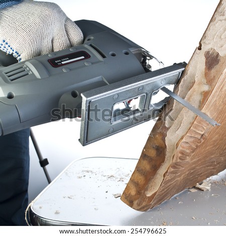 man carpenter builder working with electric jigsaw and wood