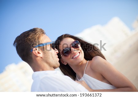 Couple on beach. Young happy man and woman sea shore smiling romantic looking each other, summer ocean vacation holiday blue sky
