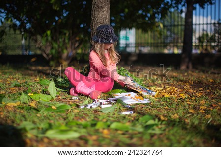 Child drawing  in Autumn Park. Creative kids development concept.