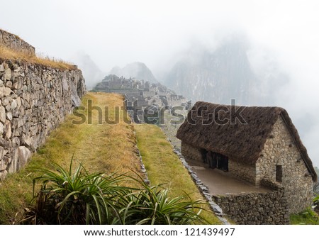 Morning views of Machu Picchu as tourists shelter in hut from rain