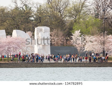 WASHINGTON DC - APRIL 8: Visitors at Martin Luther King Memorial in Washington DC with cherry blossoms on April 8, 2013. The memorial opened to the public on August 22, 2011.