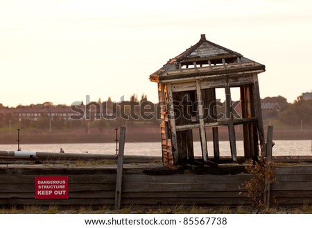 Collapsing shelter on pier by the side of the Mersey in Liverpool at sunset
