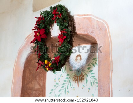 Christmas wreath outlines painting of angel at Mission La Purisima Conception in California State Park in Lompoc