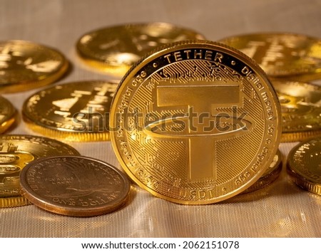 Concept of Tether coin against golden bitcoin coins and a single US dollar coin. Tether is backed by US dollar and used for trading in alt coins