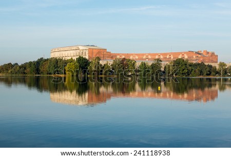 The remains of the large Congress Hall or Kongresshalle at the Nazi Parade grounds and reflected in still lake in Nuremberg, Germany