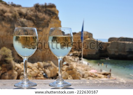 Two glasses of white wine on the background of beach, sea  and cliff