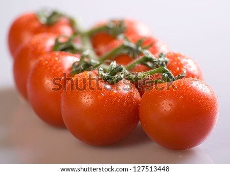 Bunch of red tomatoes. The tomatoes are a little wet.