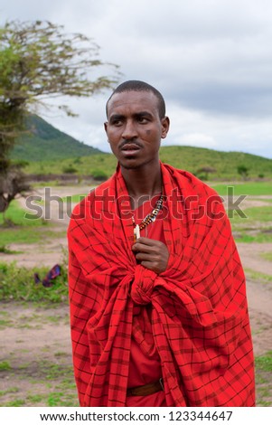 MASAI MARA, KENYA - DECEMBER 28: An unidentified African man poses for a portrait on December 28, 2009 in Masai Mara, Kenya. Masai are a Nilotic ethnic group of people located in Kenya and Tanzania.
