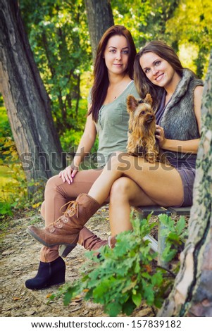 Friends in the park / Beautiful girlfriends are in the park with their dog, in autumn
