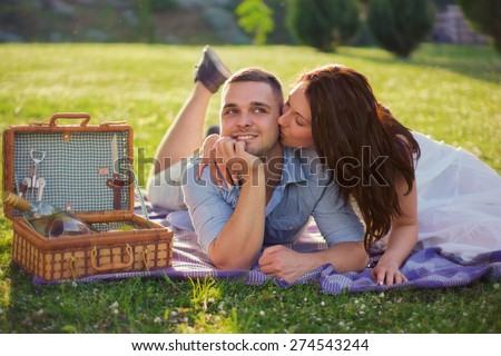 Attractive Couple Enjoying Romantic Sunset Picnic in the Countryside / Outdoor photo with custom white balance, color filters, and some fine film grain added