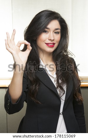 Young smiling fashion business woman say ok on white background