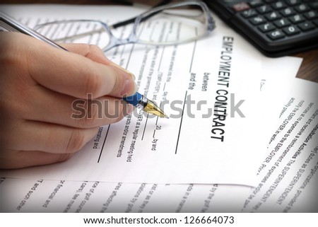 woman\'s hands signing an employment contract, close-up