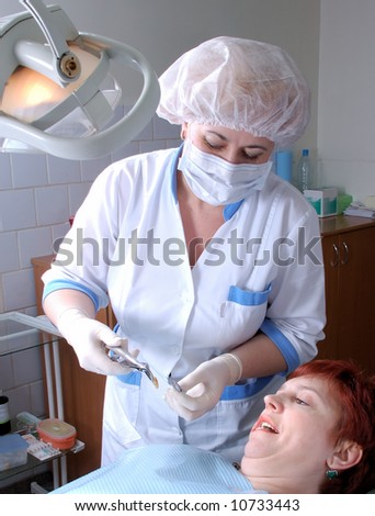 doctor to extract a wisdom tooth and woman with open mouth look at tooth