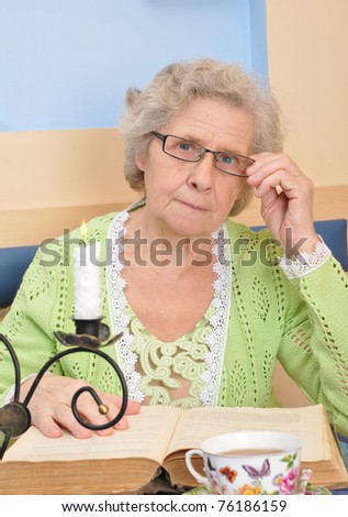 senior woman holding a book for reading