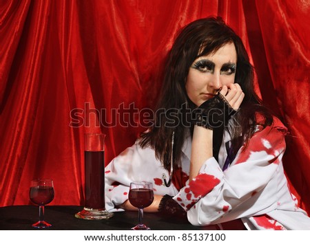 pale woman in the role of a vampire on red background