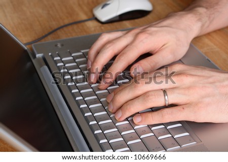 Typing on a laptop - selective focus on left hand