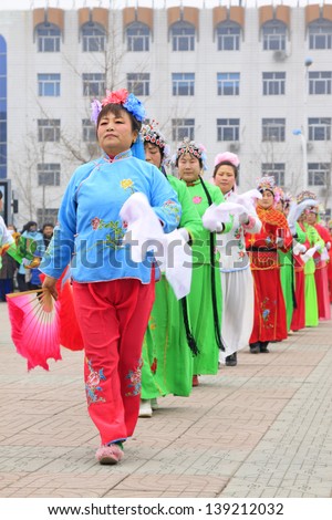 LUANNAN COUNTY - FEBRUARY 21: During the Chinese Lunar New Year, people wear colorful clothes, yangko dance performances in the street, on February 21, 2013, Luannan County, Hebei Province, China.