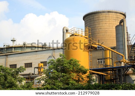 yellow metal cans and cooling tower in the factory, closeup of photo