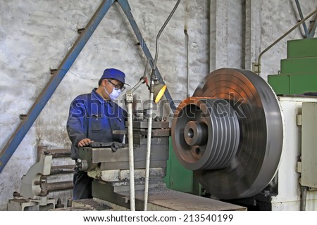 TANGSHAN CITY - JUNE 20: worker working in the machine tool in the production workshop, on June 20, 2014, Tangshan city, Hebei Province, China