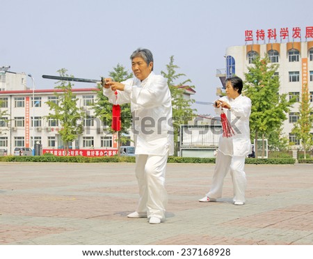 LUANNAN COUNTY - SEPTEMBER 20: Old women Fencing performance in a square on September 20, 2014, Luannan county, Hebei Province, China