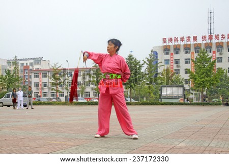 LUANNAN COUNTY - SEPTEMBER 20: Old woman Fencing performance in a square on September 20, 2014, Luannan county, Hebei Province, China