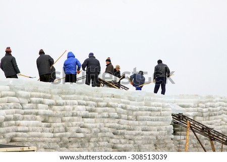 LUANNAN COUNTY - JANUARY 24: Farmers arrange ice cubes on embacle in the winter on January 24, 2015, Luannan County, Hebei Province, China