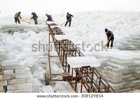 LUANNAN COUNTY - JANUARY 24: Farmers transportation ice with a conveyor belt in the winter on January 24, 2015, Luannan County, Hebei Province, China