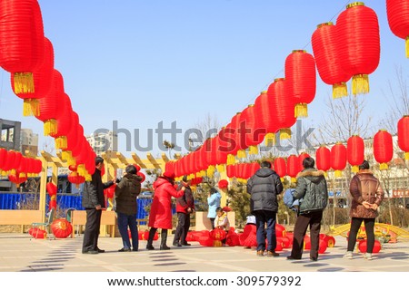 LUANNAN COUNTY - MARCH 5: On the Lantern Festival Day, People were busy with hanging red lanterns in a park, March 5, 2015, luannan county, hebei province, China