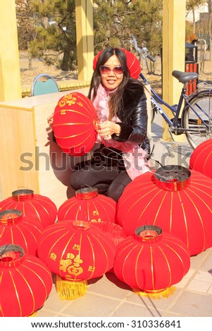 LUANNAN COUNTY - MARCH 5: On the Lantern Festival Day, A lady taking photo with red lanterns in a park, March 5, 2015, luannan county, hebei province, China