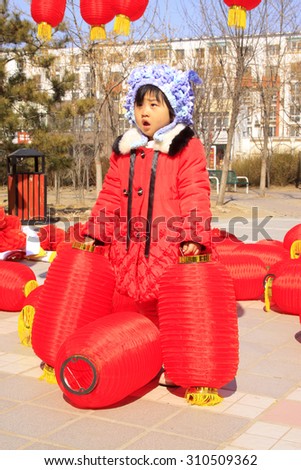 LUANNAN COUNTY - MARCH 5:  A child plays with red lanterns during the Lantern Festival Day on March 5, 2015, Luannan county, Hebei province, China