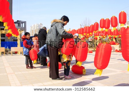 LUANNAN COUNTY - MARCH 5: On the Lantern Festival Day, people were busy with hanging red lanterns in a park, March 5, 2015, luannan county, hebei province, China