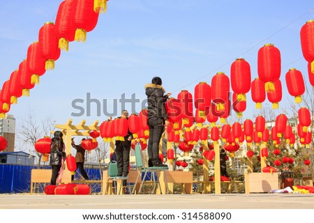 LUANNAN COUNTY - MARCH 5: On the Lantern Festival Day, People were busy with hanging red lanterns in a park, March 5, 2015, luannan county, hebei province, China