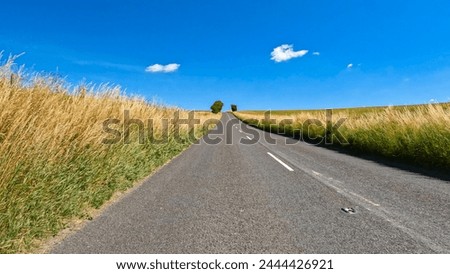 Similar – Foto Bild Leere Asphaltstraße inmitten eines schneebedeckten Feldes unter einem Himmel mit Nordlicht