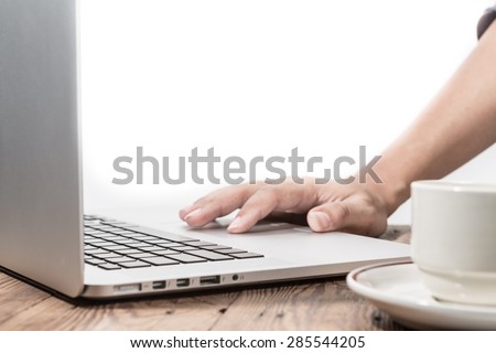 hand using laptop on office desk. Warm tone.