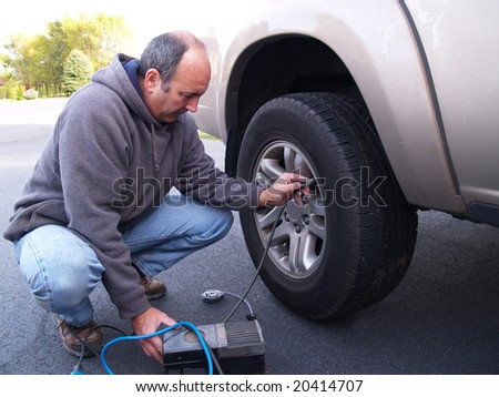 man checking air pressure in truck tire